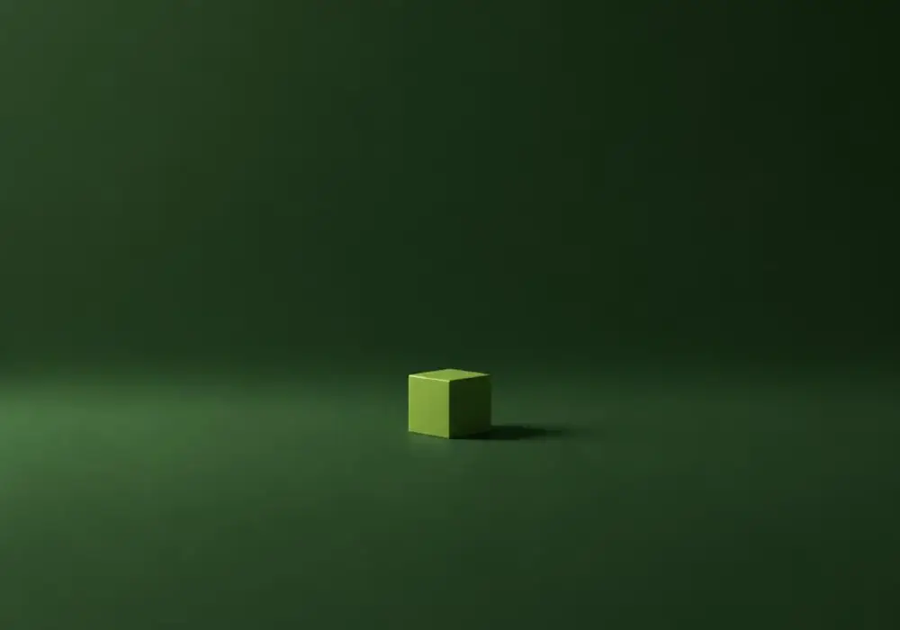 One small lime cube alone on a wide empty plane