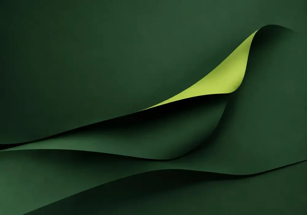 A folded green sheet lifting to reveal a bright layer beneath